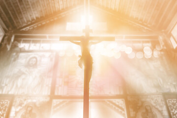 silhouette Jesus Christ crucifixion on cross over orange sunset light inside church background, prayer and praise religion concept