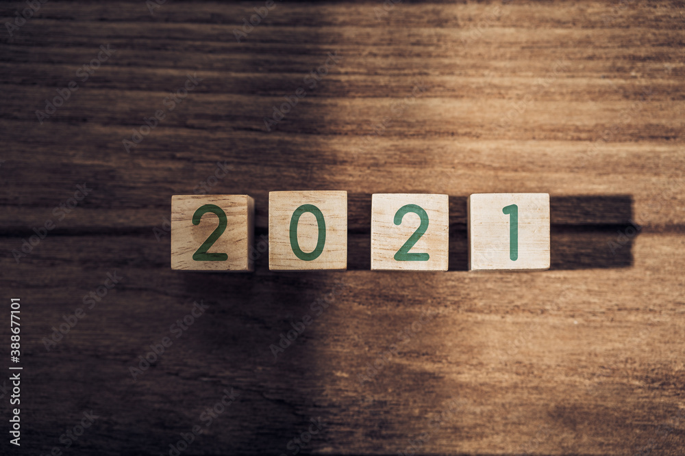 Aufkleber 2021 happy new year on wood block on wood table and concrete wall with sunlight from window.hope new year concept