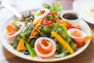 A delicious smoked salmon garden salad with cherry tomatoes in dash close up.
