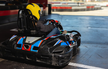 Young woman driving sport car for karting, going outdoor in sport club.