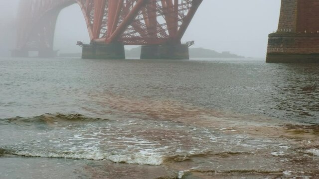 Close-up view of the Forth Bridge enshrouded in mist, a cantilever railway bridge across the Firth of Forth and a symbol of Scotland, UK