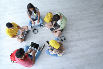 Students with modern devices studying online indoors