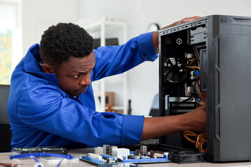 African-American technician repairing computer in service center