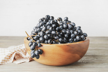 Bowl with sweet ripe grapes on table