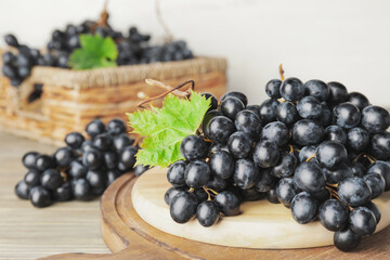 Board with sweet ripe grapes on table