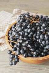 Bowl with sweet ripe grapes on table