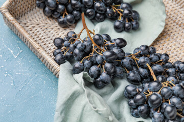 Wicker tray with sweet ripe grapes on table