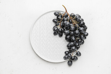 Plate with sweet ripe grapes on table