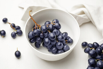 Bowl with sweet ripe grapes on table