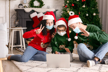 Family with laptop celebrating Christmas at home due to coronavirus epidemic