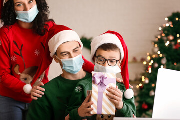 Family with laptop celebrating Christmas at home due to coronavirus epidemic