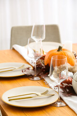 Beautiful table setting with pumpkins in dining room