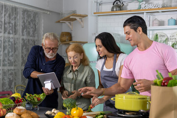 Elderly parent or senior adults having good time with their children cooking foods together at home