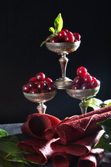 Berry the sweetness from the cherries in a metal bowl on a dark background. Natural product without colorants and preservatives. The pastille is rolled up in the form of a tube. 