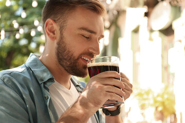 Handsome man with cold kvass outdoors. Traditional Russian summer drink