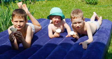 children sunbathe on the mattress and eat ice cream