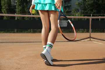 Sportswoman playing tennis at court on sunny day, closeup