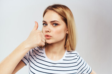 Fototapeta premium emotional woman in striped t-shirt gesture with hands lifestyle light background