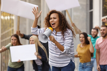 Emotional African American young woman with megaphone at protest outdoors - obrazy, fototapety, plakaty