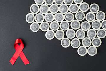 AIDS ribbon with condom on black background