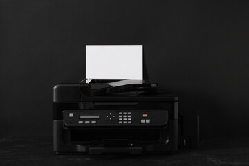 Modern printer with paper on black background