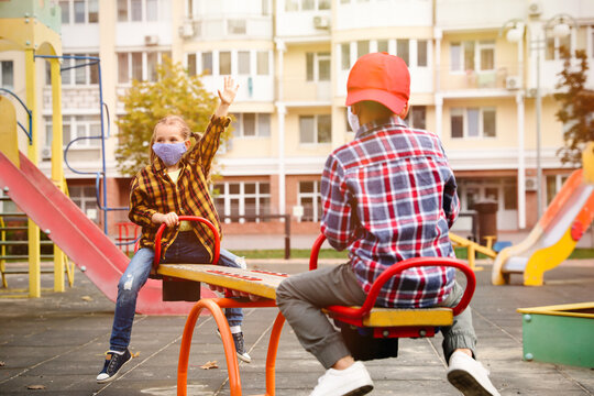 Little Children With Medical Face Masks On Playground During Covid-19 Quarantine