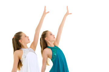 Two Sisters in Sport Dresses Dancing in Studio on White Background.