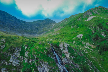 Fototapeta na wymiar Upper view of Capra waterfall or cascada on Transfagarasan highway with epic winding turns in Romania.