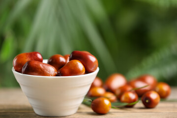 Fresh ripe oil palm fruits on wooden table, closeup. Space for text