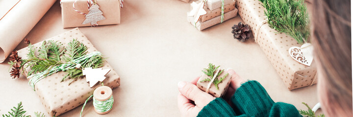 Preparing for the Christmas holidays. Gift wrapping. Woman hand with little gift box