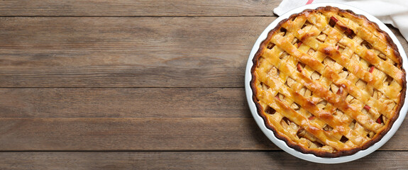 Traditional apple pie and space for text on wooden table, top view. Banner design