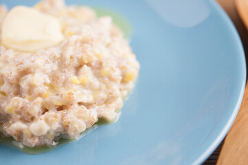 Breakfast: Healthy food classic porridge in blue dish on wood background. oatmeal food breakfast. Close up.