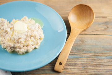Breakfast: Healthy food classic porridge in blue dish on wood background. oatmeal food breakfast. Close up.