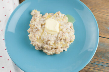 Breakfast: Healthy food classic porridge in blue dish on wood background. oatmeal food breakfast. Top view.