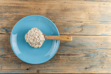 Breakfast: Healthy food classic porridge in blue dish on wood background. oatmeal food breakfast. Top view.