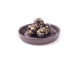 Healthy homemade energy cereal balls of black sesame and almond in ceramic plate isolated on a white background..