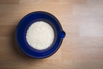 Jasmine rice in bowl on wooden background.
