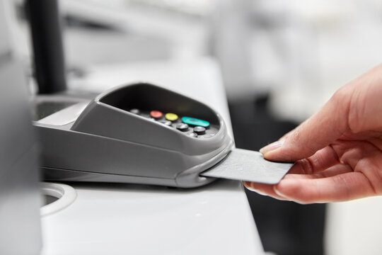 shopping, payment and finance concept - close up of hand with credit card in card-reader