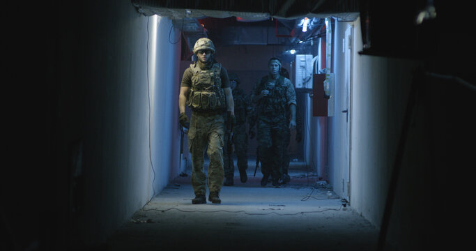 Professional SWAT team walking in dark hallway