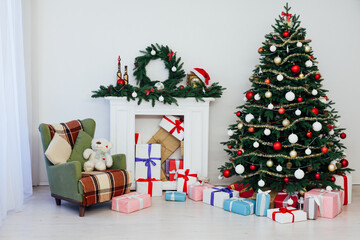 Christmas tree with gifts by the fireplace for the new year decor of the house 2021 2022
