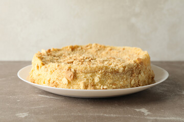Plate with delicious Napoleon cake on gray table