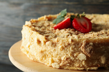 Stand with Napoleon cake with strawberry on wooden background