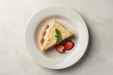 Plate with delicious Napoleon cake on white - gray background