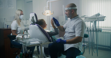Professional dentist curing teeth of teen girl