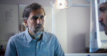 Dentist examining mature male patient