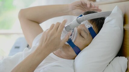 Obstructive sleep apnea therapy,hd video.
Healthy senior man wearing ventilator mask and adjusting to fit his face ,healthcare concept. - Powered by Adobe