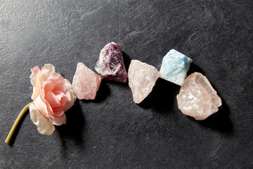occult science, minerals and geology concept - quartz crystals, gem stones and rose flower on slate...