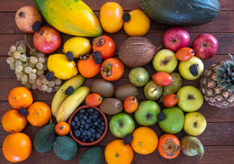 Directly above view of freshly picked fresh fruit mix. Lifestyle and healthy eating, detox and vegan food on a rustic wooden table.