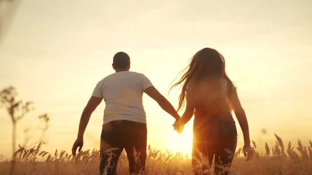 happy family couple and dog run hands in the park. concept of team business concept travel freedom victory happiness teamwork. happy family run parents hold hands run sunlight in sunset in the park