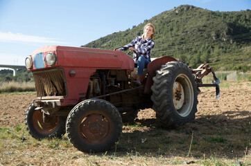 Obraz premium Positive woman working on garden plow, preparing soil for seedlings planting in springtime..